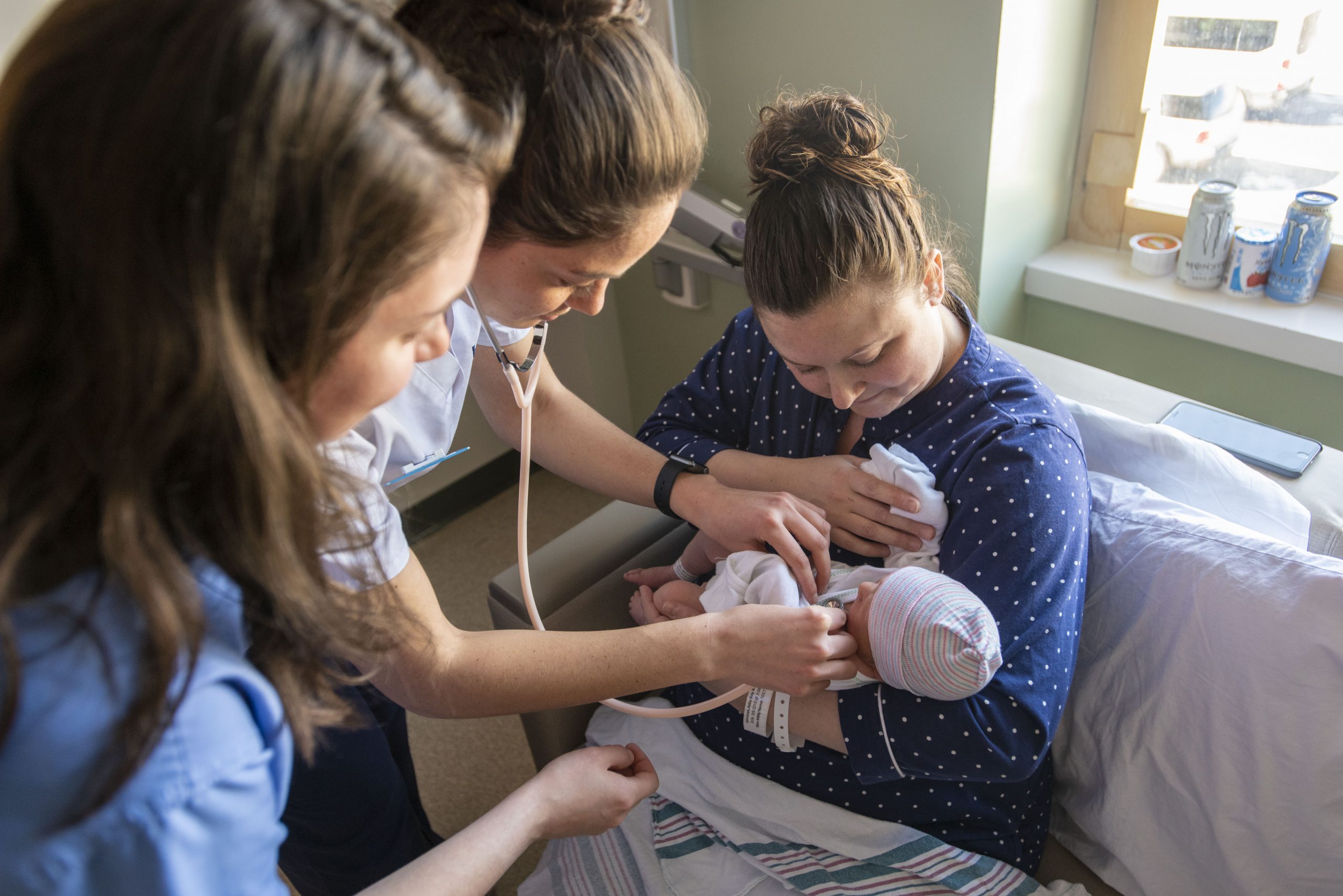 Dressed in white, Rachel Calabro ’19 (NURS) assists Courtney Tobin, RN, ’13 in Labor and Delivery during an internship she has at UConn Health on March 6, 2019. (Sean Flynn/UConn Photo)