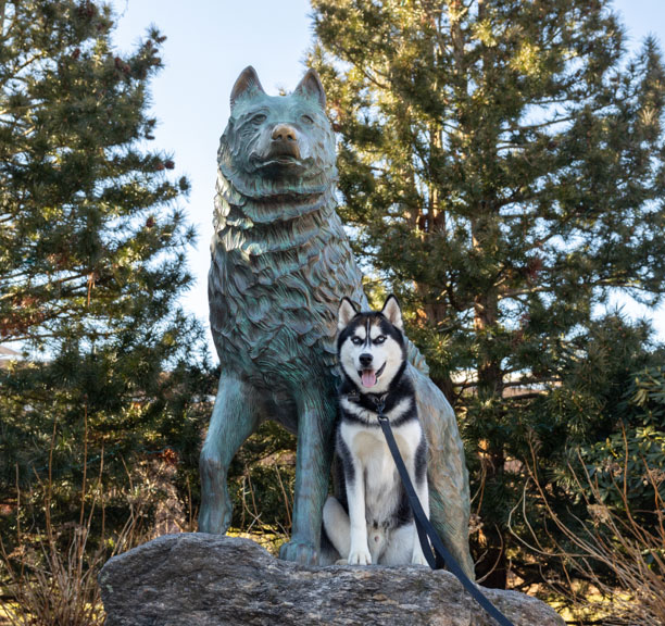 Cool photo of Jonathan sitting with the Jonathan statue on the UConn Campus.